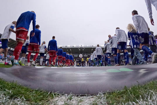Lagen på väg in för line up innan fotbollsmatchen i