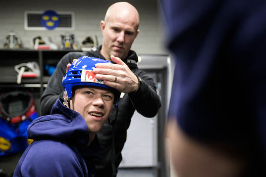 Lucas Raymond of Sweden gets his helmet adjusted