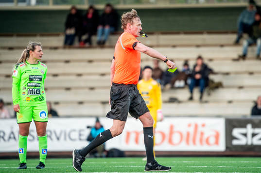 Domare Niklas Andersson tar fram det gula kortet