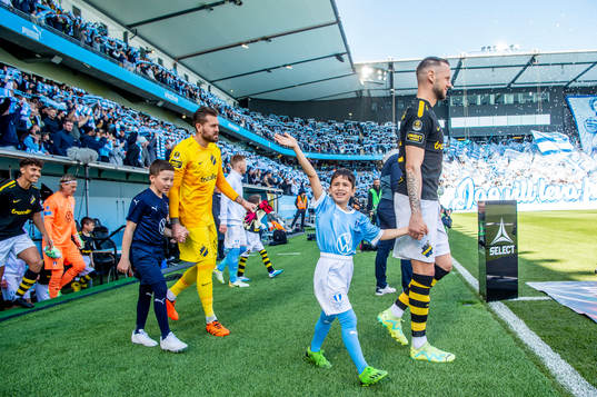 Spelarna kommer in på arenan innan fotbollsmatchen i