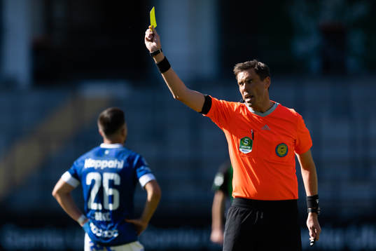Domare Magnus Lindgren delar ut ett gult kort