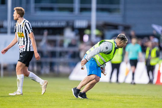 Arenapersonal plockar upp inkastade föremål