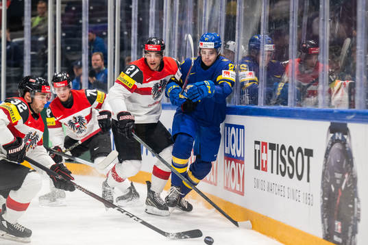 Bernd Wolf and Lukas Haudum of Austria compete for the puck
