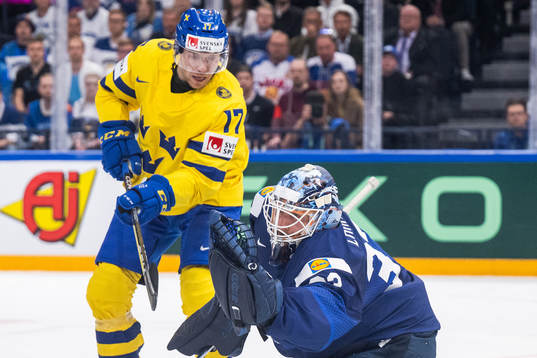 Pär Lindholm of Sweden and goaltender Emil Larmi of Finland