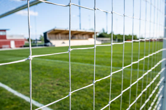 Nät i fotbollsmålet på Tornvallen med läktare i