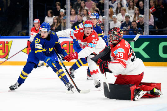 Leo Carlsson of Sweden against Anders Koch and goaltender