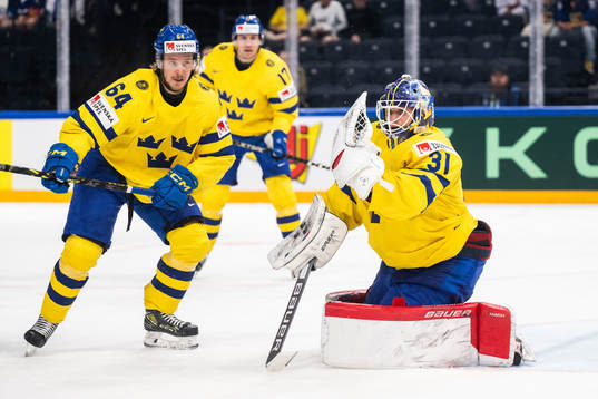 Jonathan Pudas and goaltender Lars Johansson of Sweden