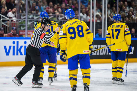 Referee Sean Macfarlane signals for a high stick and denies