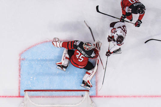 Dans Locmelis of Latvia scores 0-1 behind goaltender Samuel