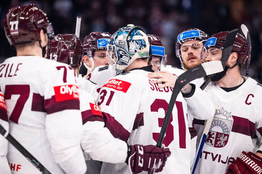 Goaltender Arturs Silovs and Miks Indrasis of Latvia hug