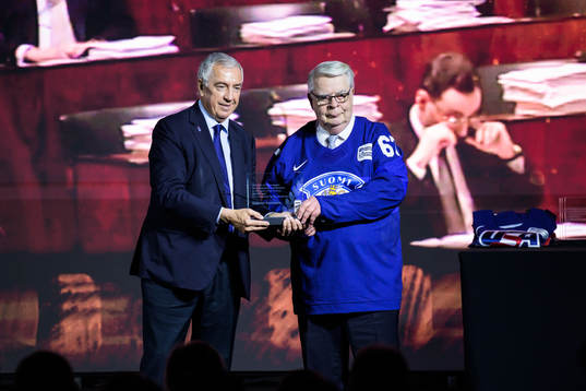Luc Tardif, president of the IIHF, hands over a trophy to