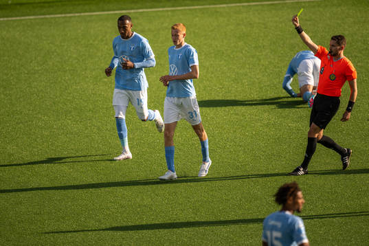 Malmö FFs Hugo Larsson varnas av domare Joakim Östling
