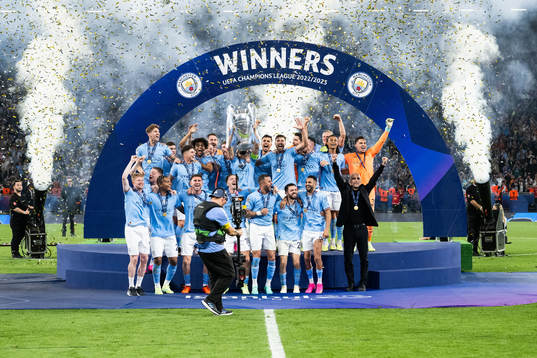 Players of Manchester City celebrate with the trophy