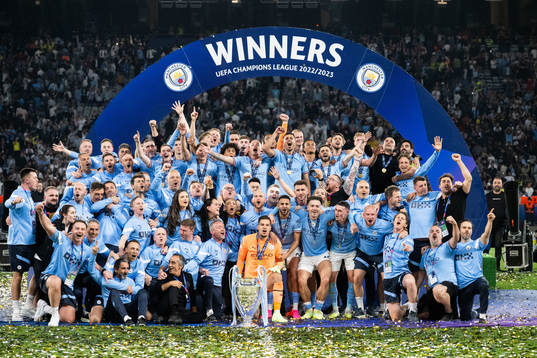 Players of Manchester City celebrate with the trophy