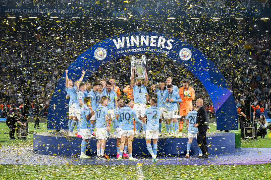 Players of Manchester City celebrate with the trophy