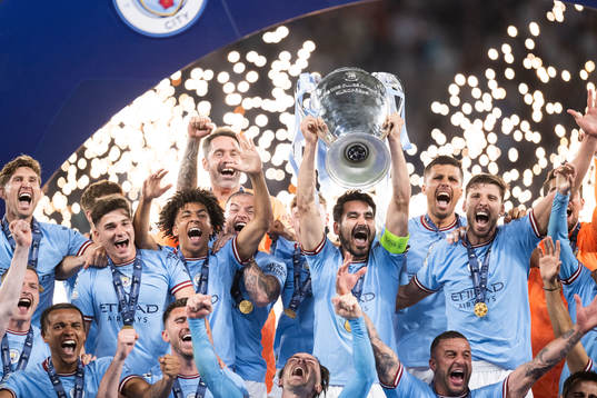 Players of Manchester City celebrate with the trophy