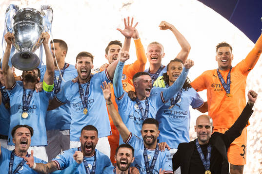 Players of Manchester City celebrate with the trophy