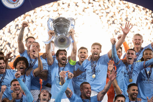 Players of Manchester City celebrate with the trophy