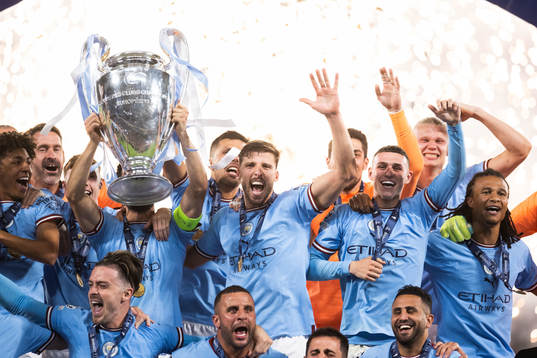 Players of Manchester City celebrate with the trophy