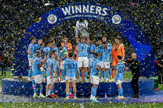 Players of Manchester City celebrate with the trophy