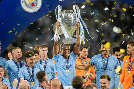 Players of Manchester City celebrate with the trophy