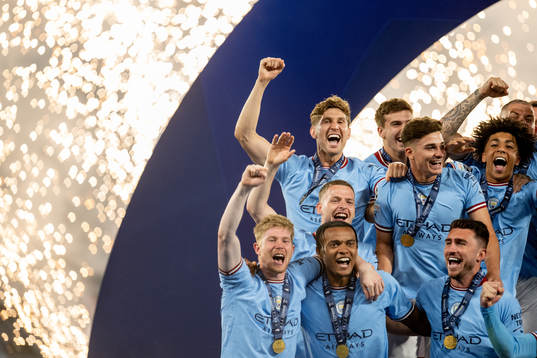 Players of Manchester City celebrate with the trophy