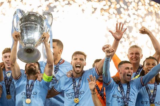 Players of Manchester City celebrate with the trophy