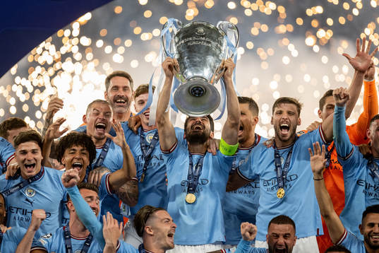 Players of Manchester City celebrate with the trophy