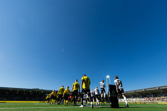Lagen på väg in för line up  innan fotbollsmatchen i