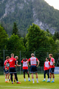 Players gather around goalkeeper coach Jonas Kolstad of the