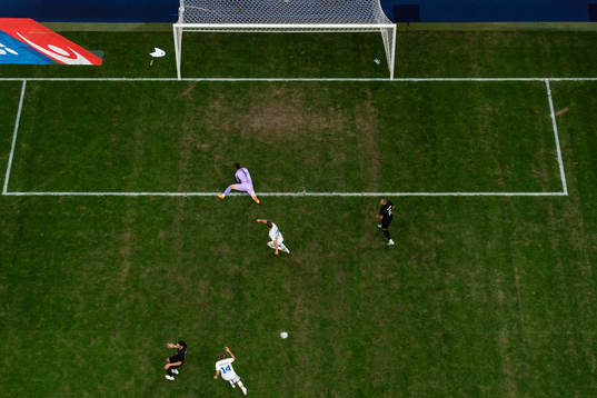Jesper Karlsson of Sweden scores 1-1 behind goalkeeper Oli