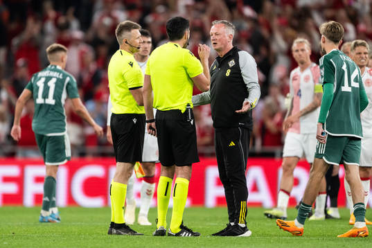Referee Daniel Stefanski and head coach Michael O'Neill of