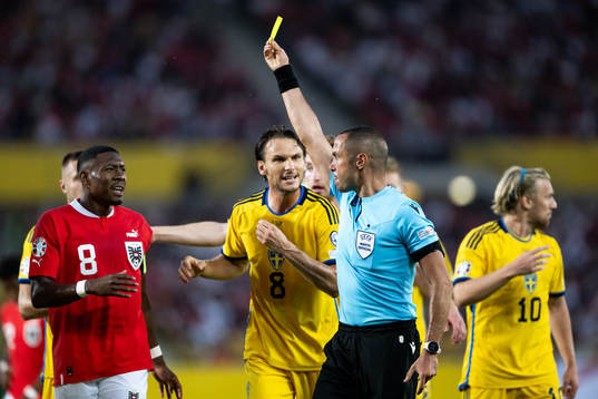 David Alaba of Austria recieves a yellow card from referee