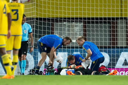 Goalkeeper Robin Olsen of Sweden receives medical attention