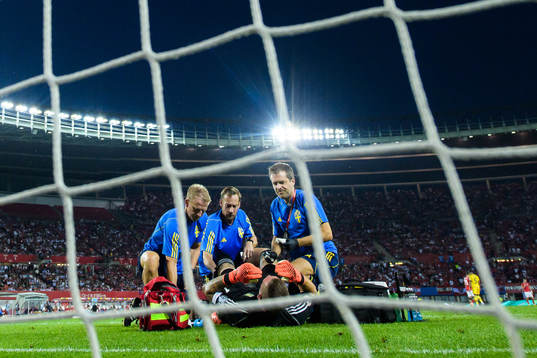Goalkeeper Robin Olsen of Sweden gets medical treatment
