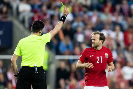 Bård Finne of Norway receives a yellow card from Referee