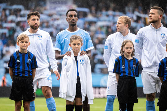 Malmö FFs Taha Ali ger sin överdragsjacka till en maskot
