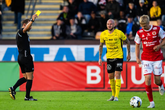 Domare Kristoffer Karlsson delar ut ett gult kort till