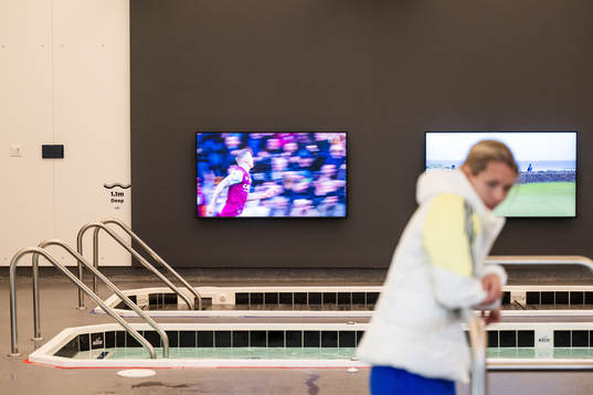Pools and TVs is seen behind goalkeeper Jennifer Falk in