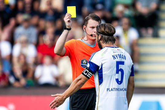 Domare Oscar Johnson ger ett gult kort till IFK