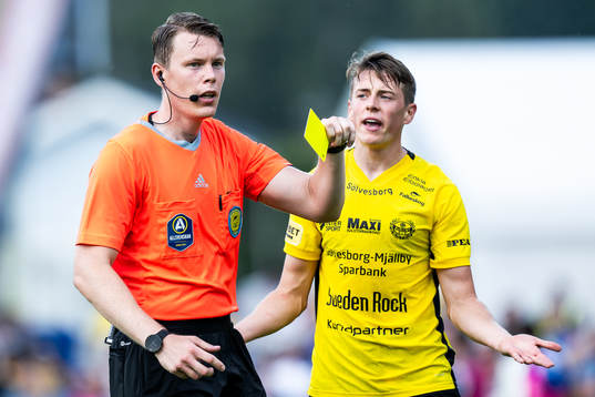 Domare Oscar Johnson ger Mjällbys Elliot Stroud ett gult