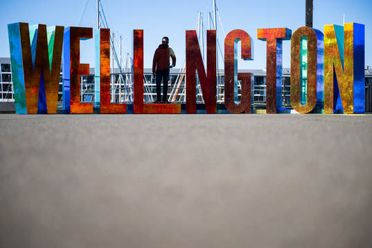 A man stands among letters spelling ”Wellington”
