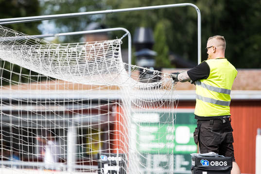 Funktionärer lagar målet innan fotbollsmatchen i