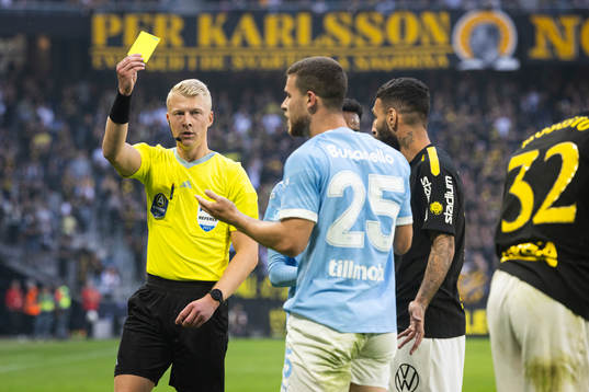 Domare Adam Ladebäck visar ett gul kort till Malmö FFs