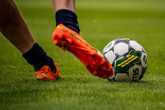 En spelare sparkar på en fotboll