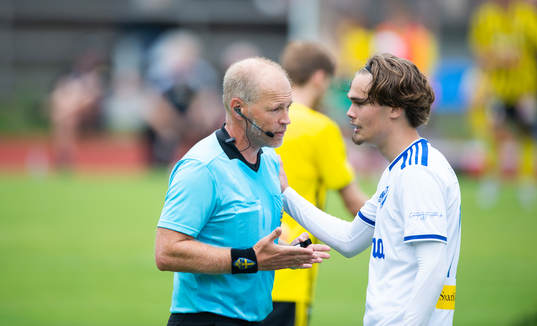 Domaren tillrättavisar en Simrishamns-spelareI matchen i