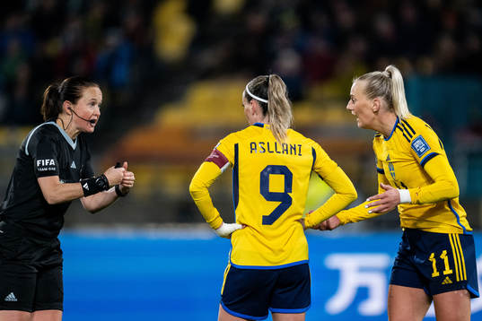 Referee Cheryl Foster in discussion with Kosovare Asllani