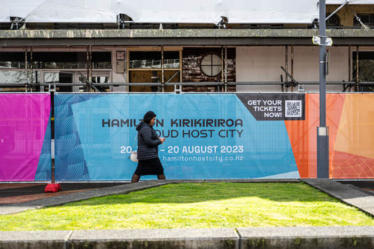 A woman walks past barriers