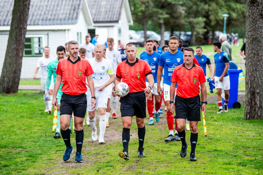 Lagen kommer in på planen innan fotbollsmatchen i Division