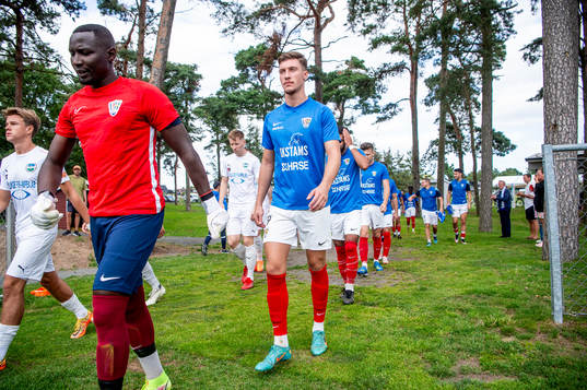 Lagen kommer in på planen innan fotbollsmatchen i Division